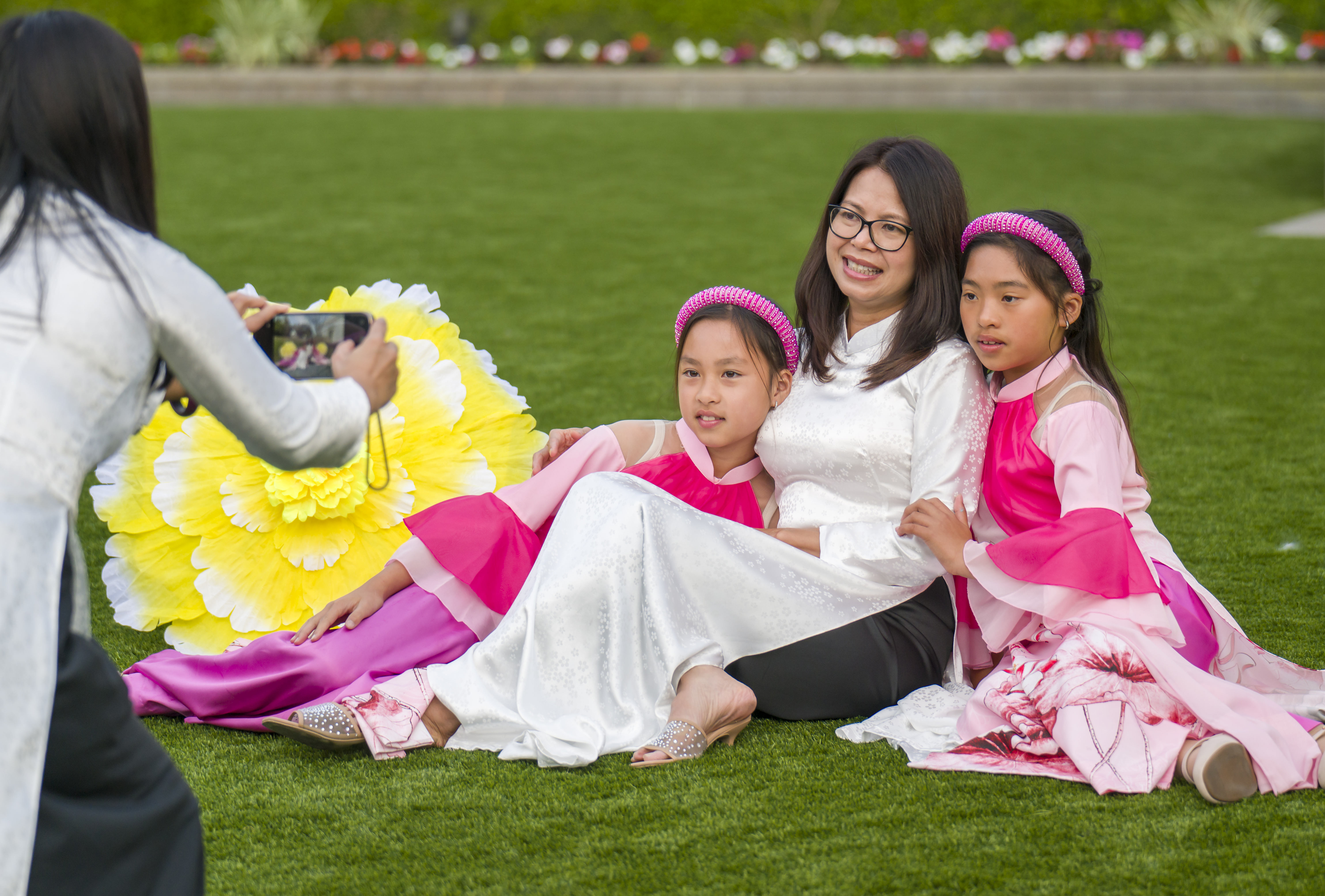 Nam Tran, left, takes a photo of dancers, Emily Vu,...