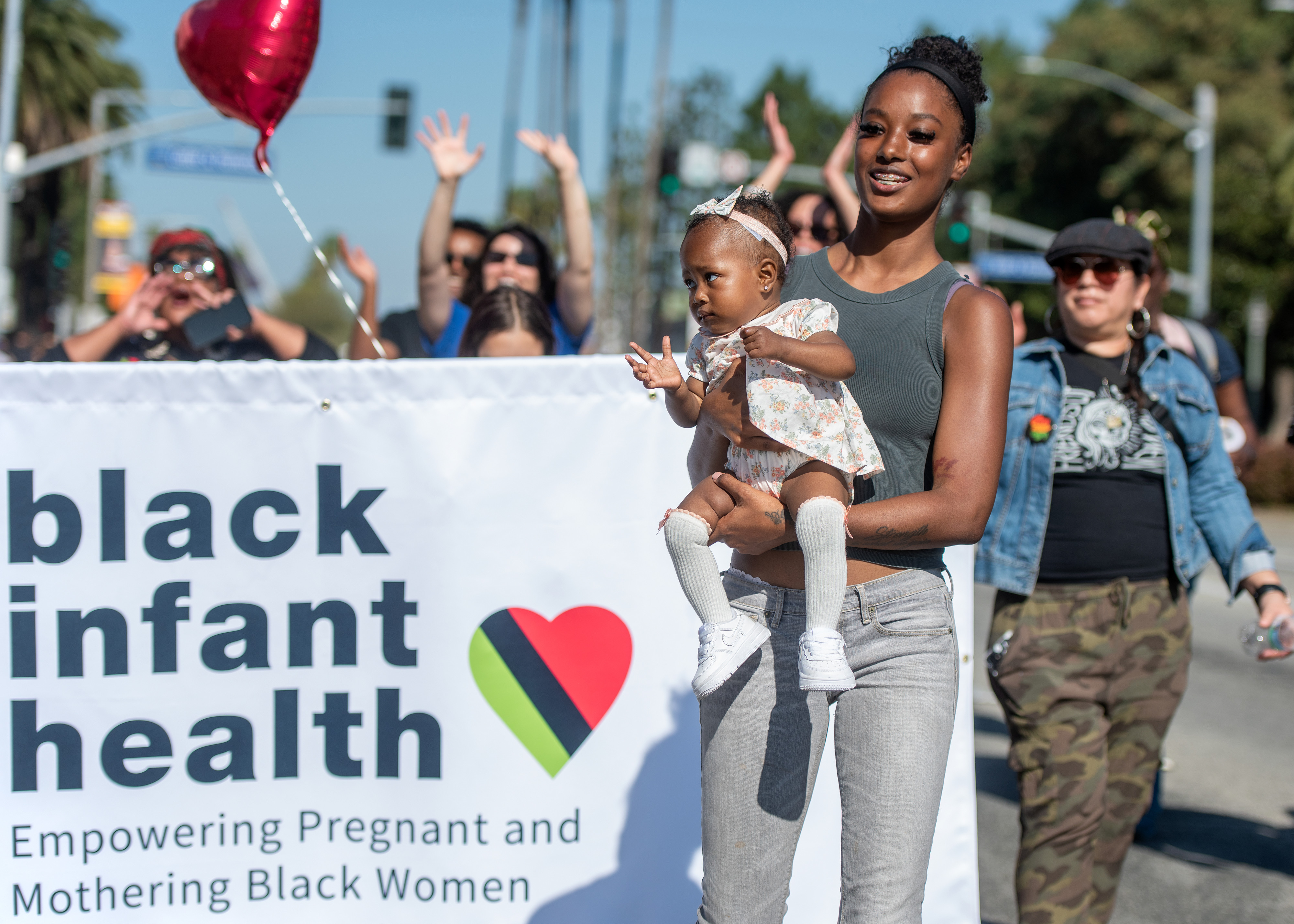 Tye Livingston of Fullerton carries Joy Livingston, 10 months, while...