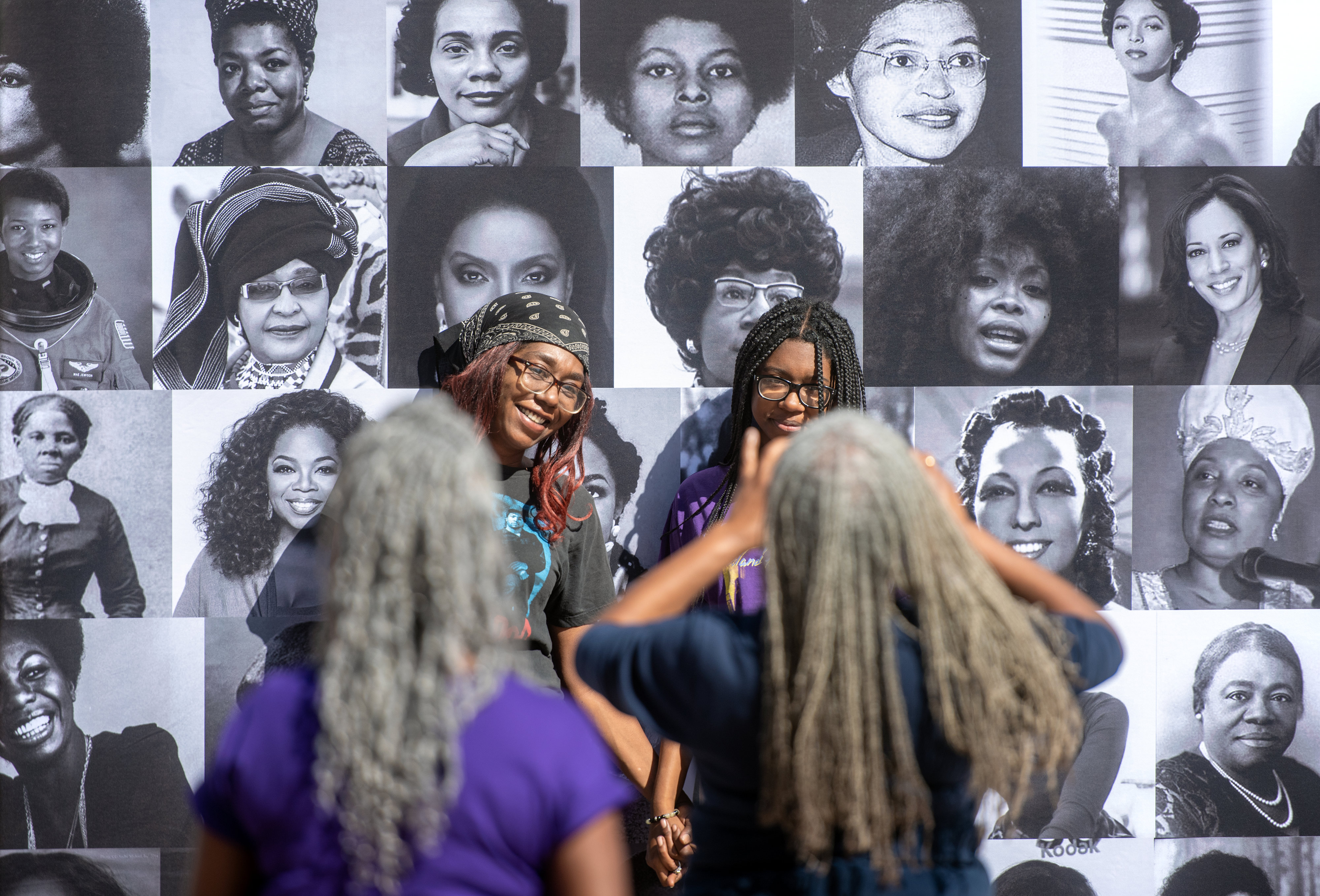 Unity Festival visitors take photos in front of a wall...