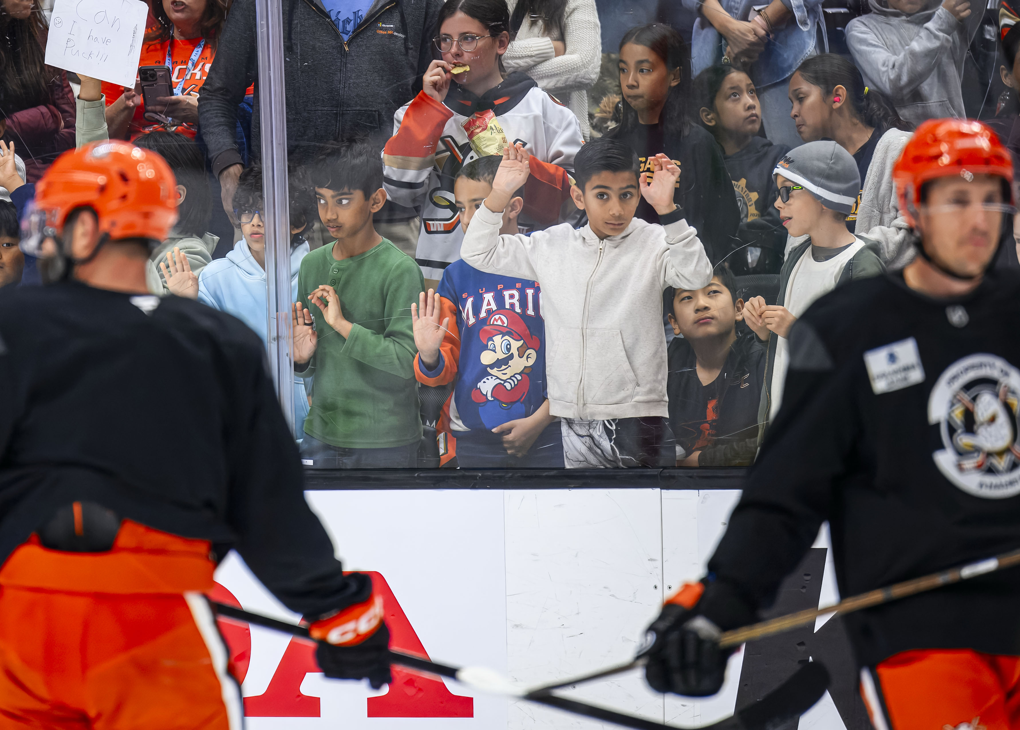 Elementary school kids watch at Anaheim Ducks players work through...