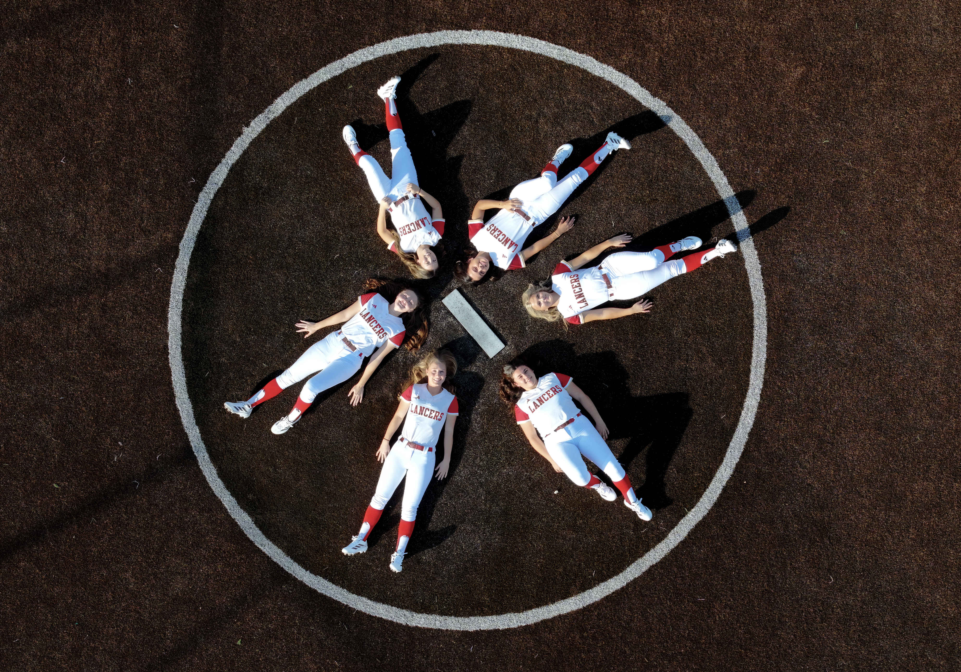 Orange Lutheran softball players, clockwise from bottom center, Carlie Snyder,...