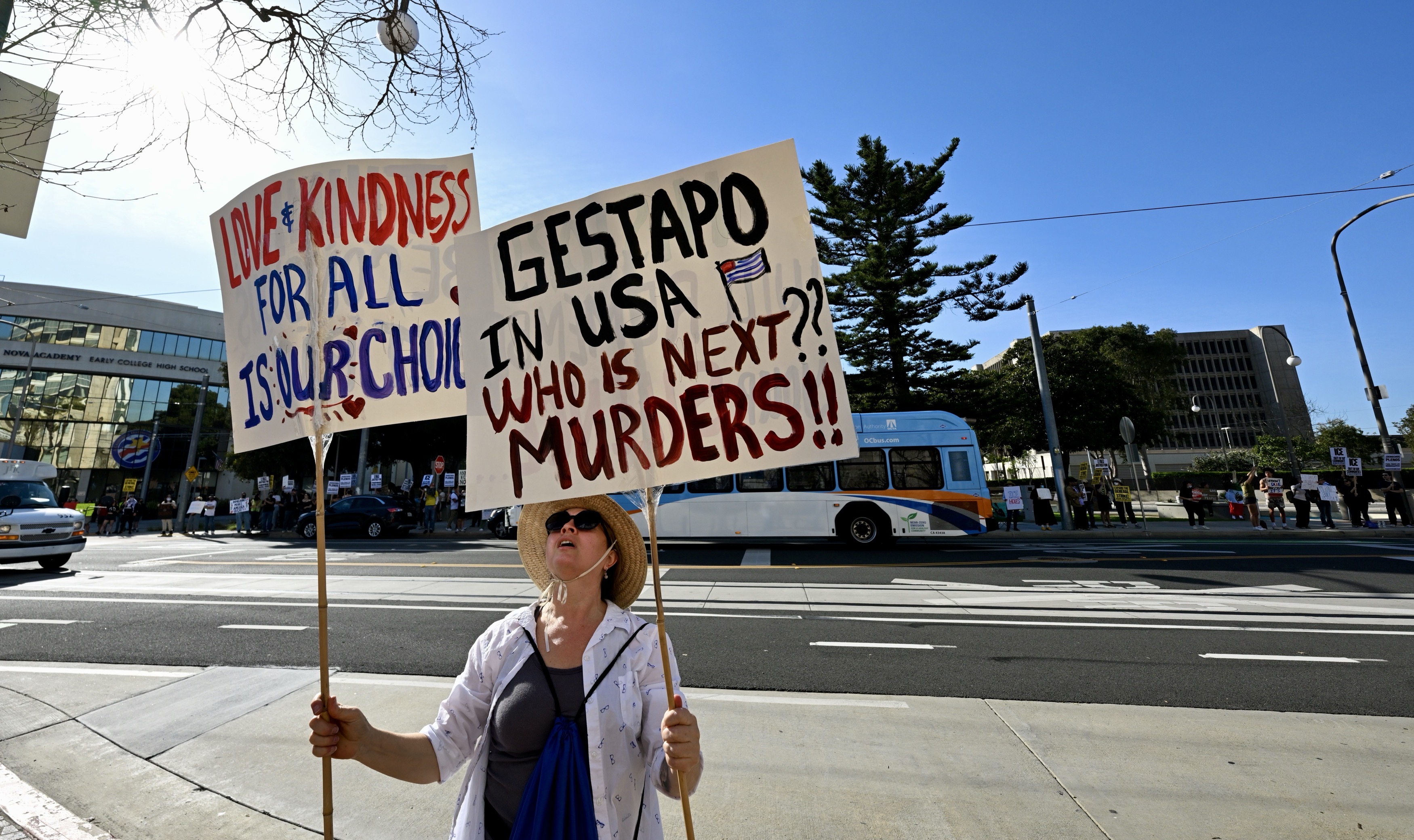 Maria Beltran holds her signs as she joins protesters along...