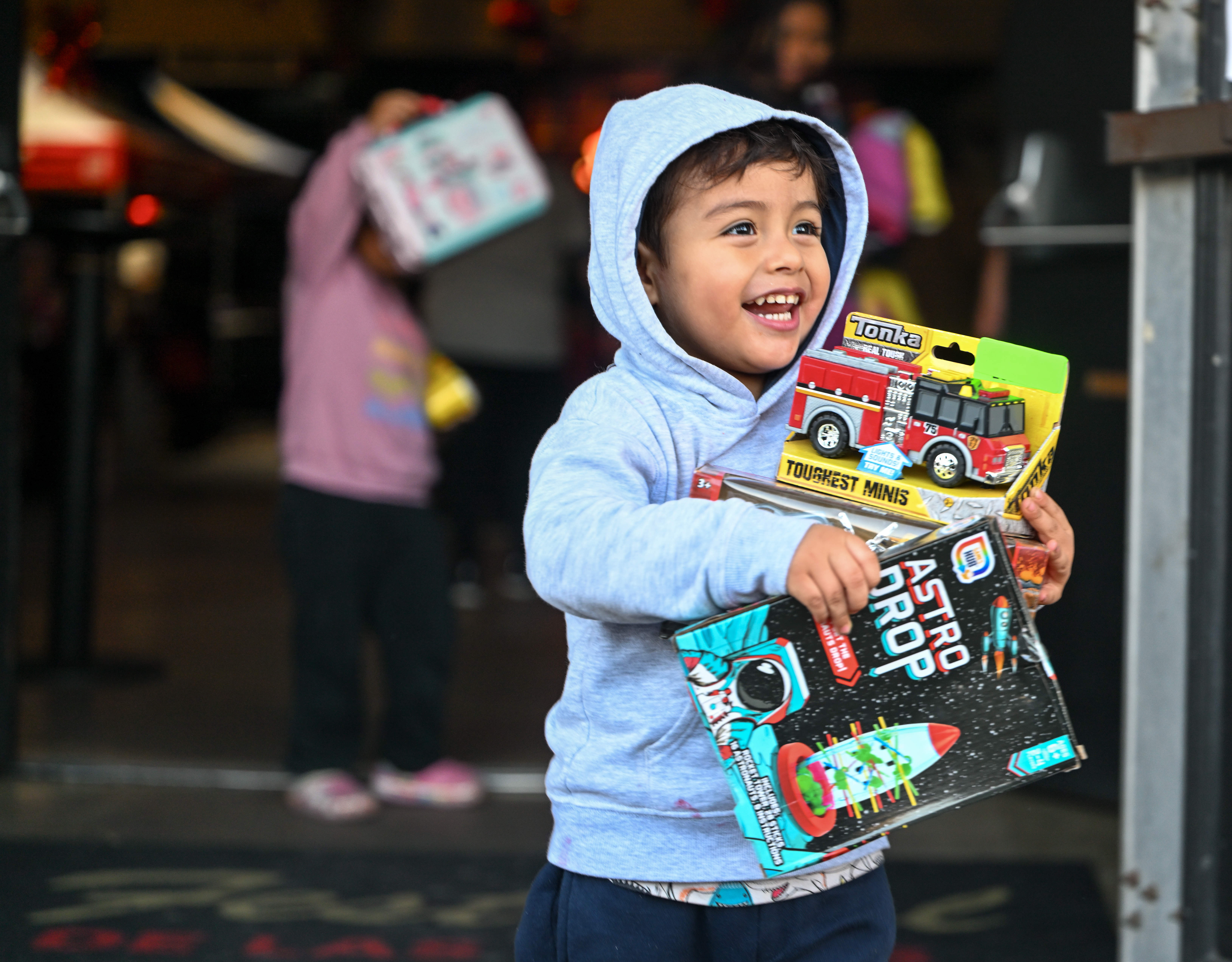 Liam Estuardo Mendez holds on to his toy haul as...