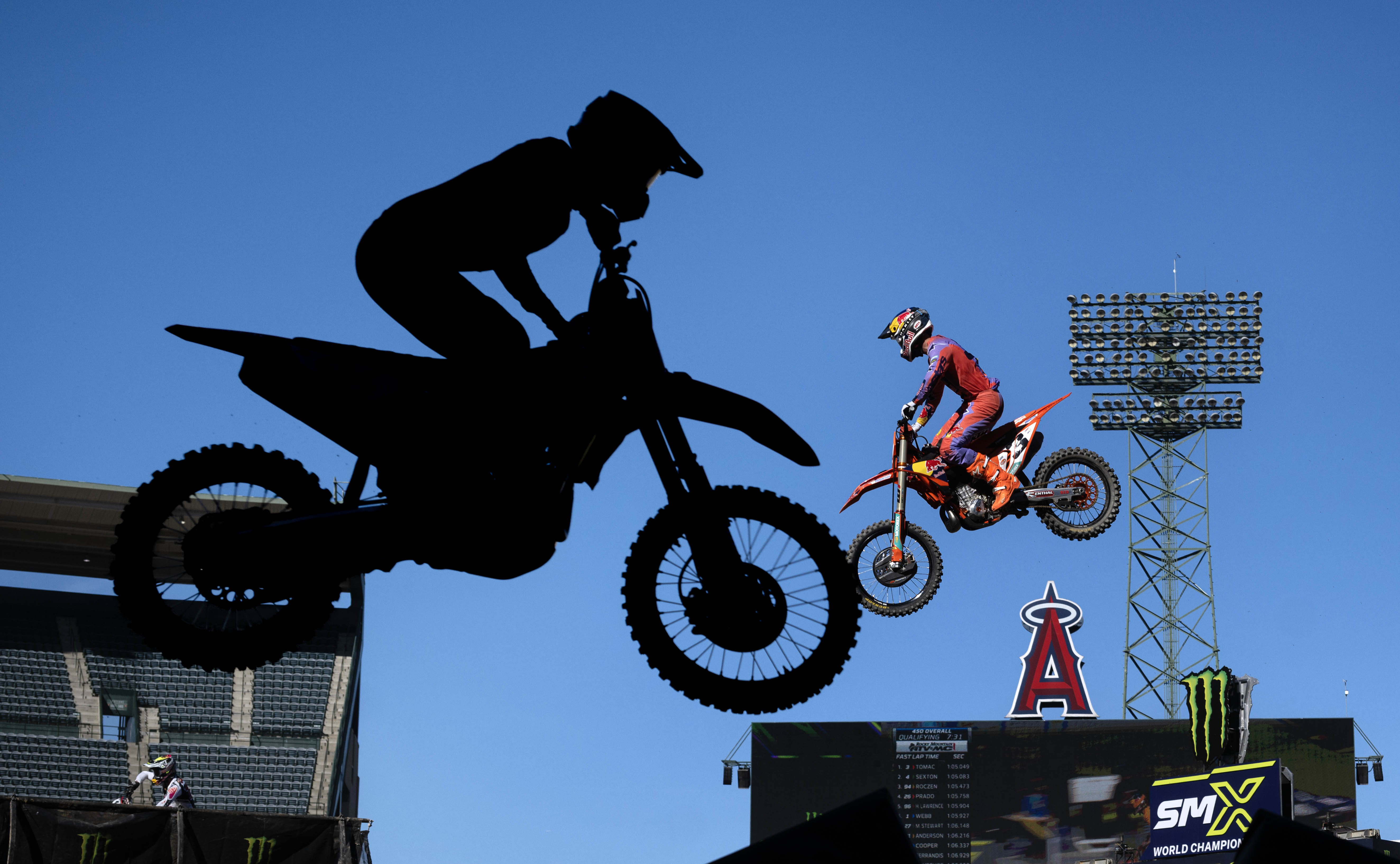 Eli Tomac, right, flies high during a qualifying round of...
