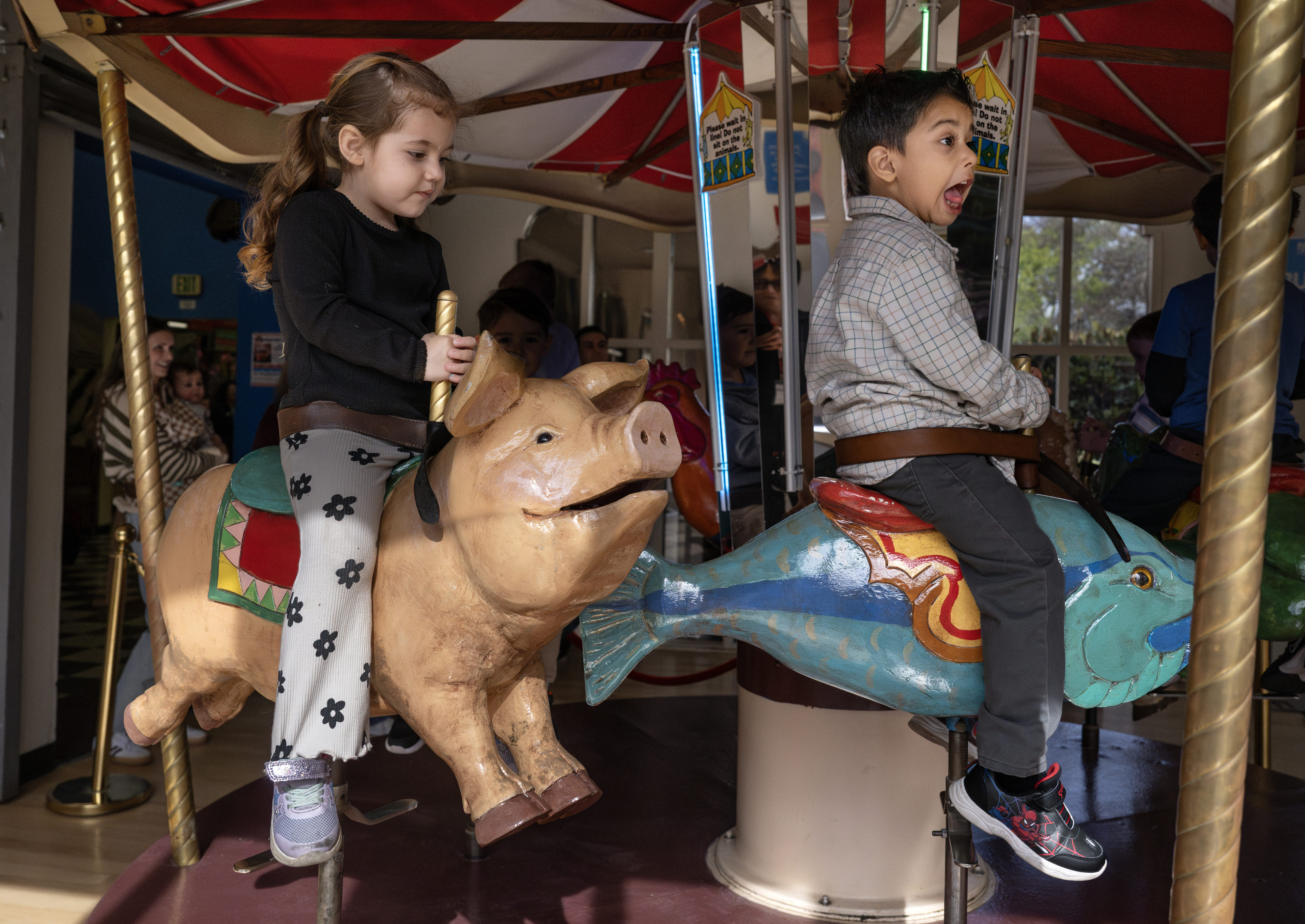Layne Ortega, 2, rides an authentic 1940s-era hand-carved carousel at...