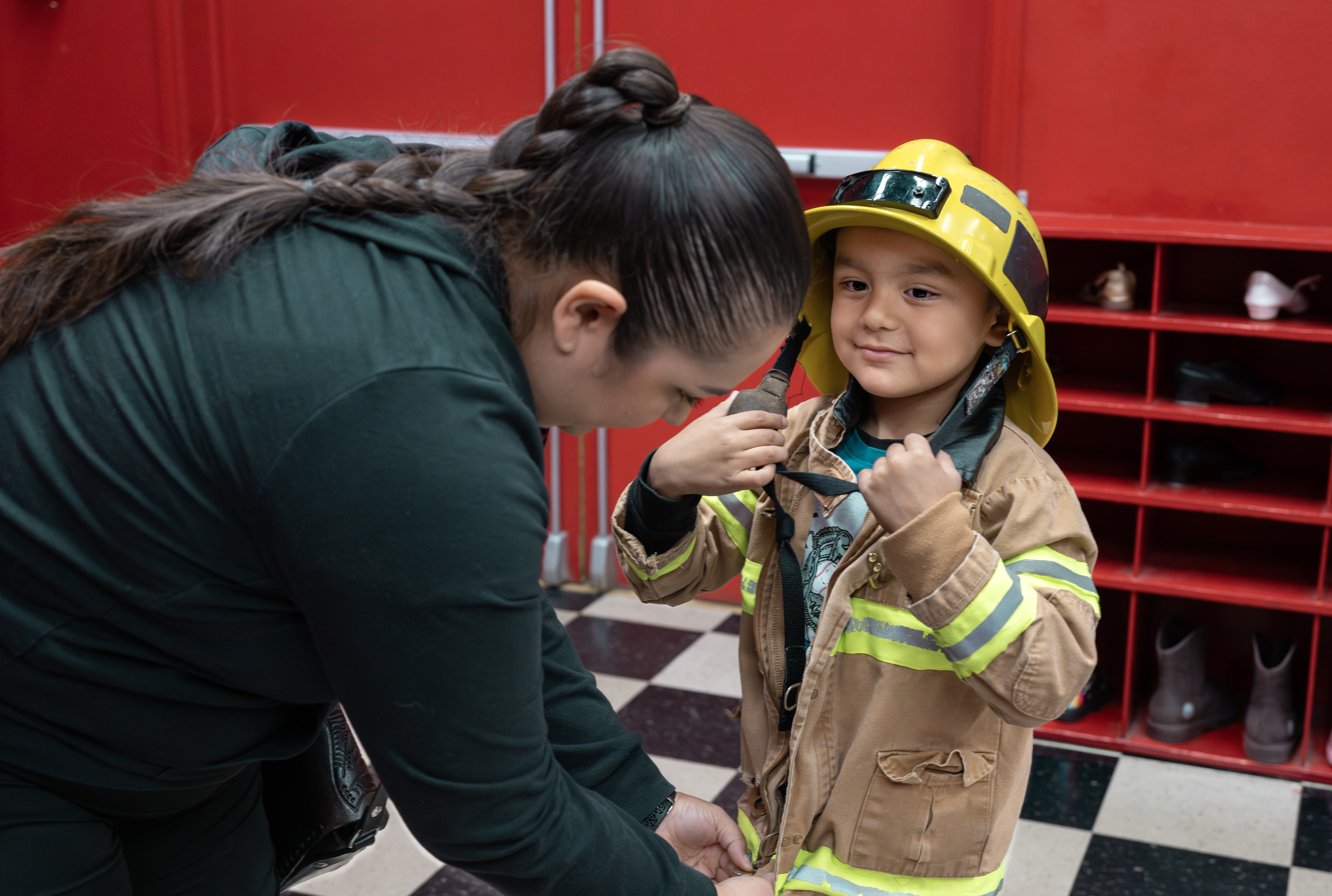 Priscilla Gonzalez helps her 4-year-old son, Ollin, get dressed up...