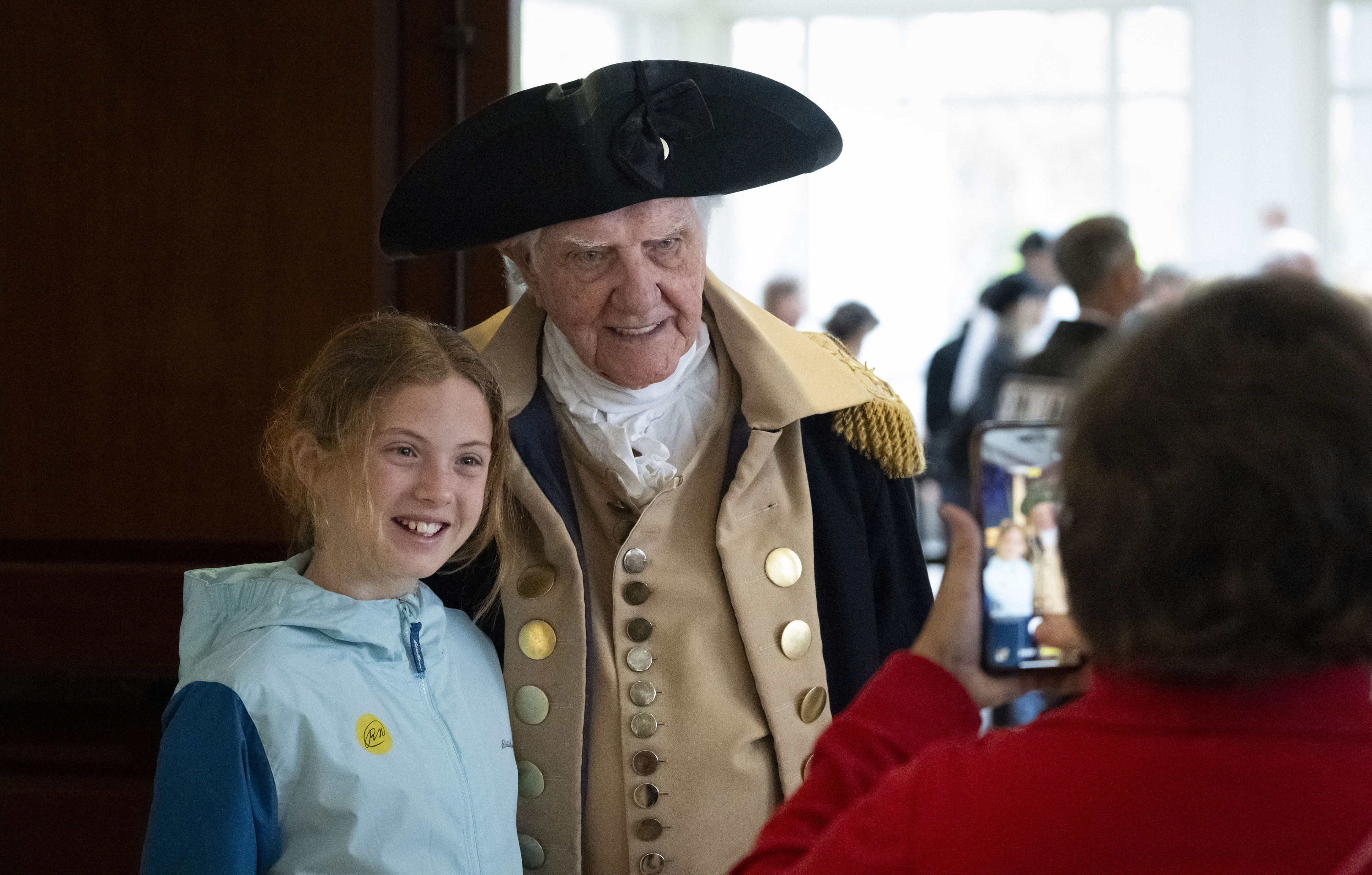 Gianna Castellano takes a photo with George Washington, played by...