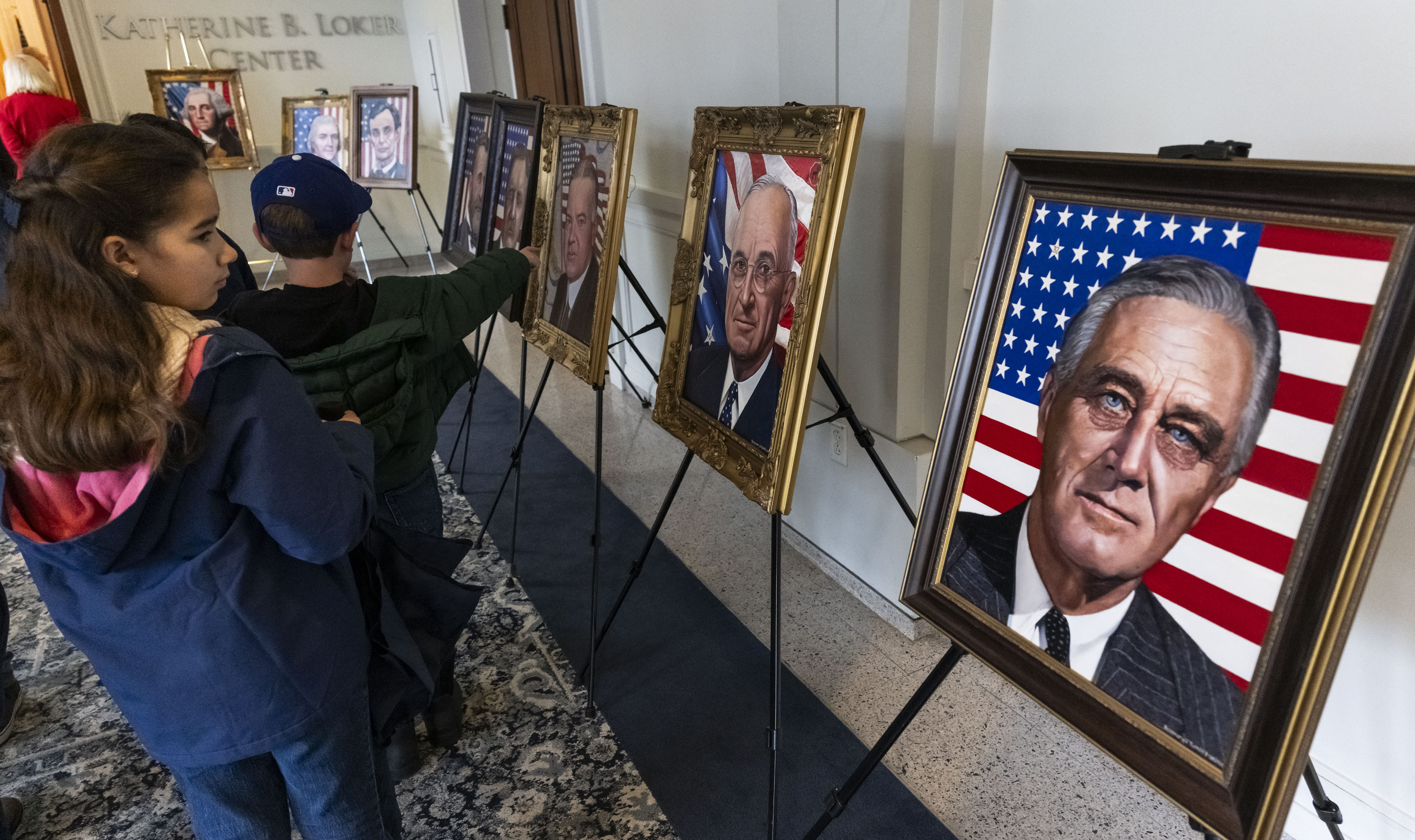 Visitors pass presidential portraits during a Presidentsâ Day celebration at...
