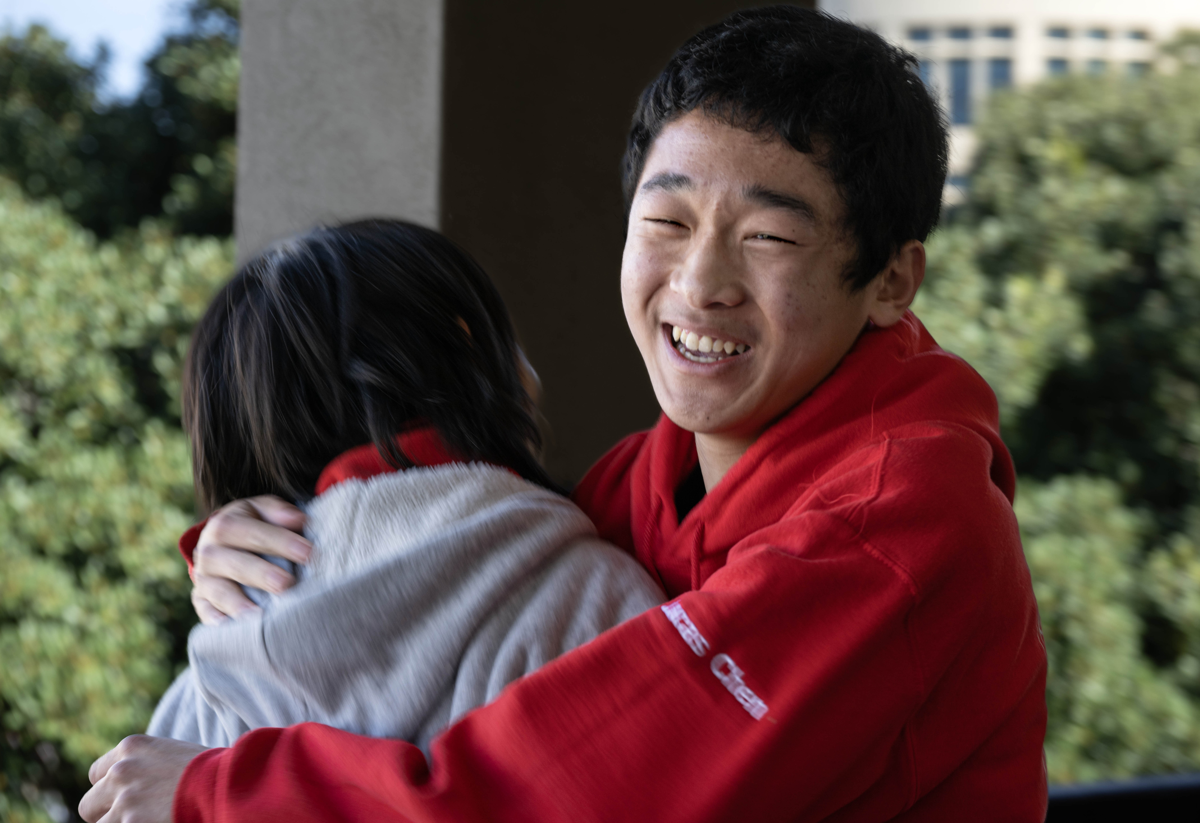 Lucas Chen, 15, right, hugs teammate Dylan Xiang, after the...