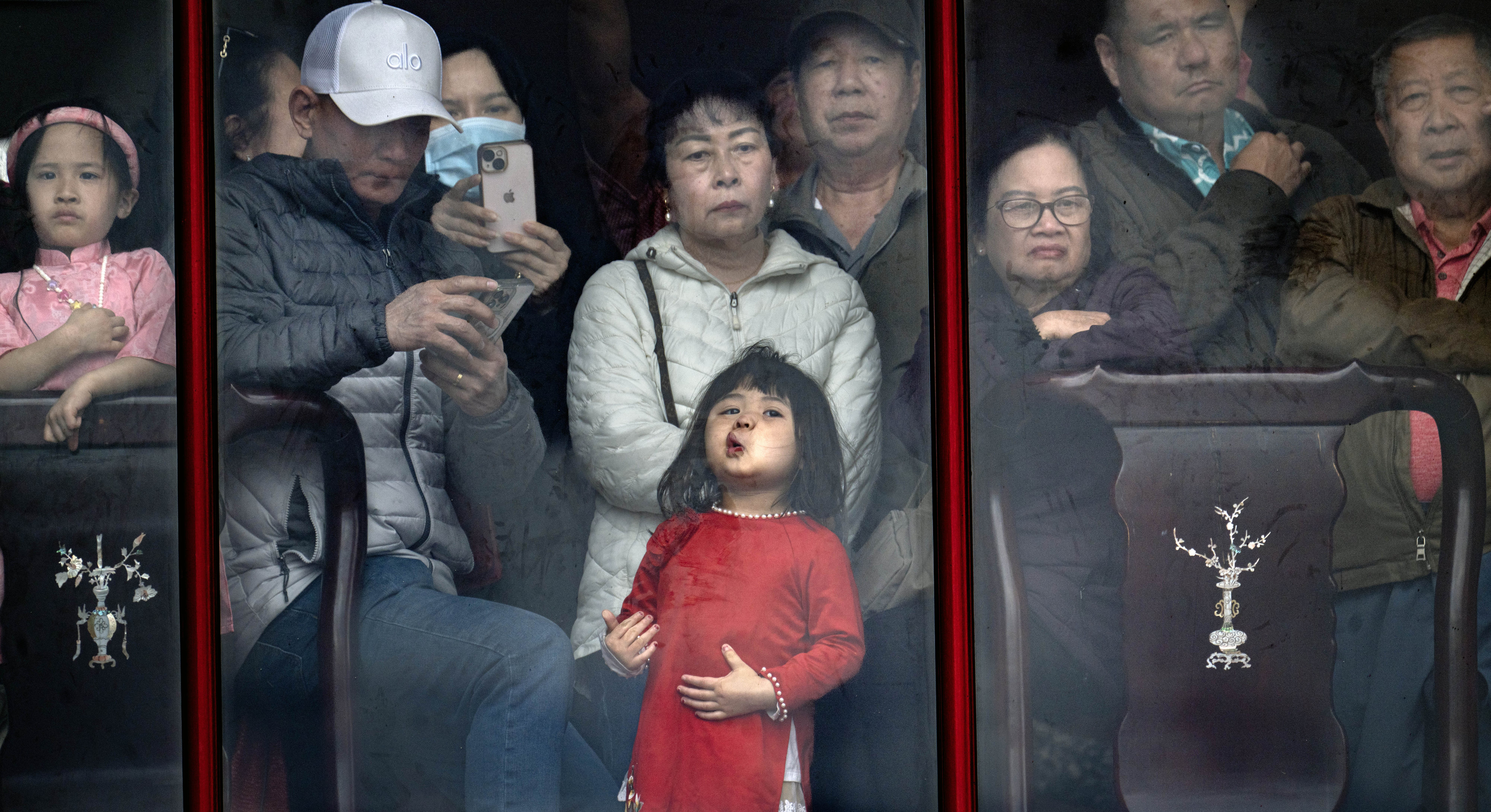 A little girl presses against a second-story window as she...