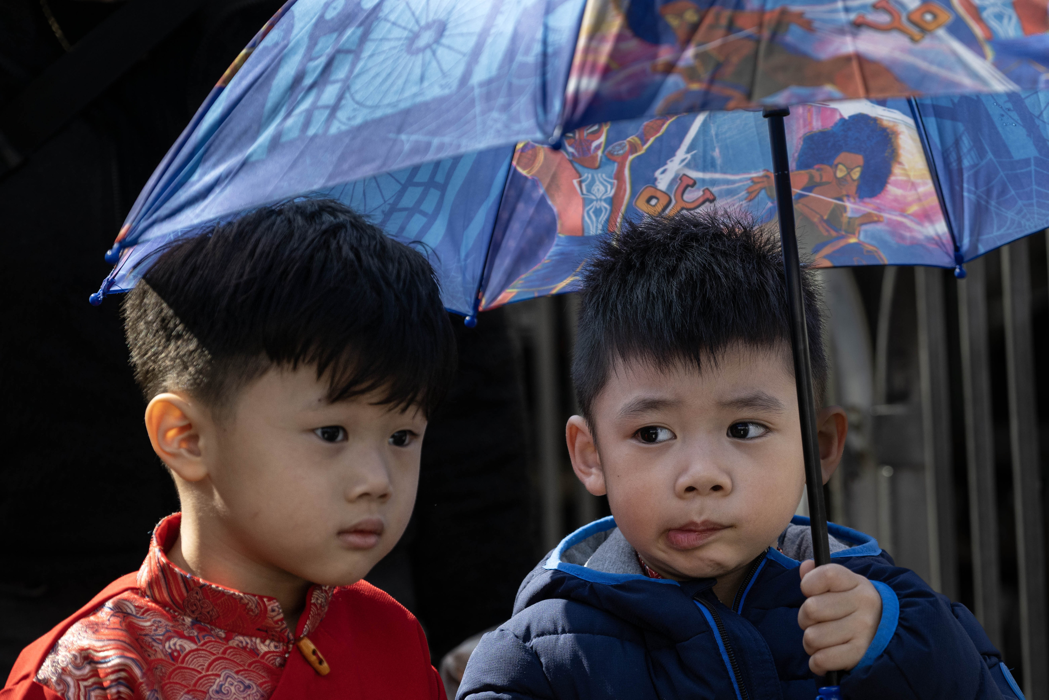 Ryan Le, 4, left, and Roland Bui, 3, stay dry...