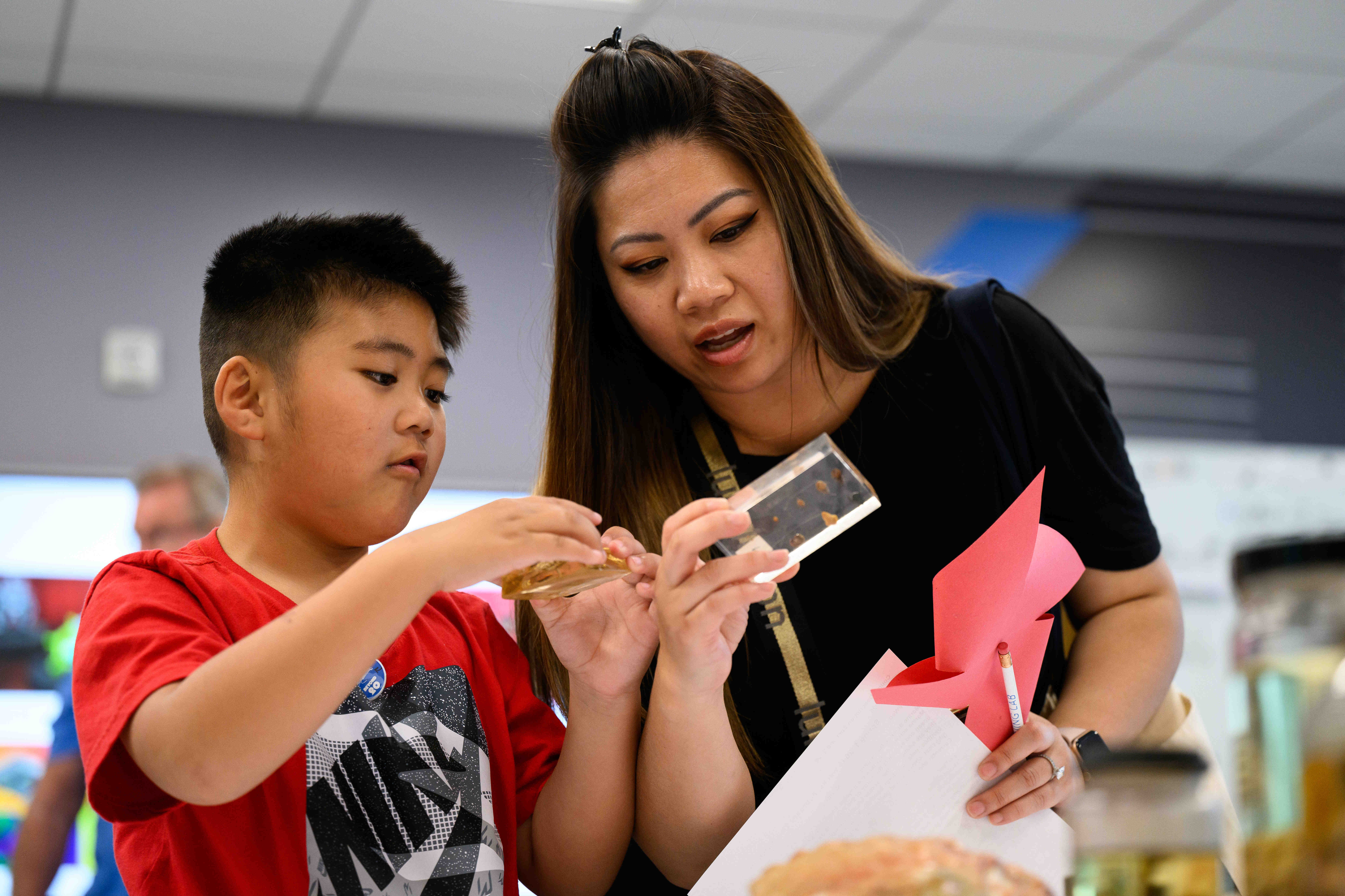 Suong Bui, right, and her son, Liam, 6, examine scientific...