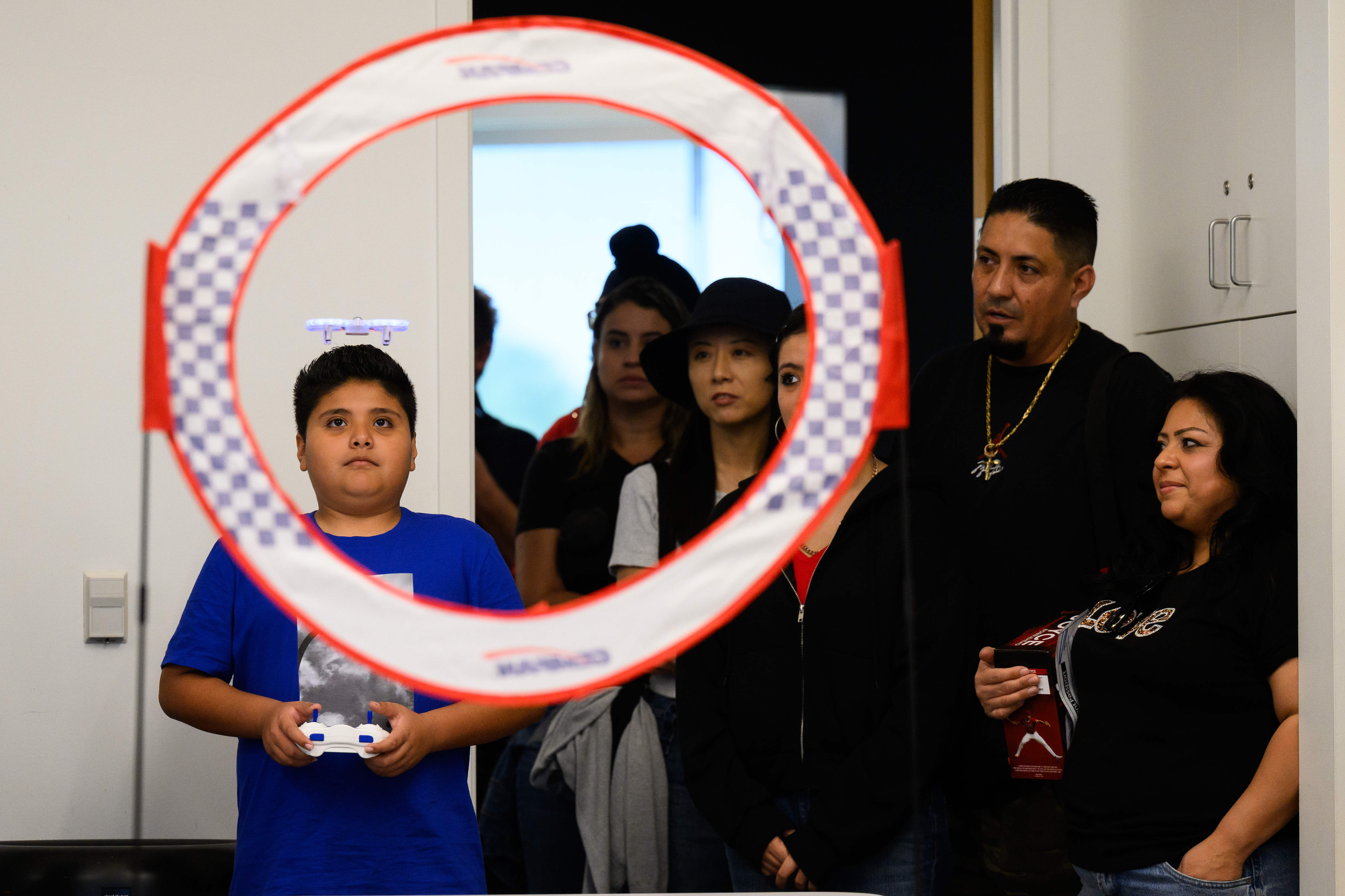 Aiden Silva, 11, left, learns to fly a drone during...