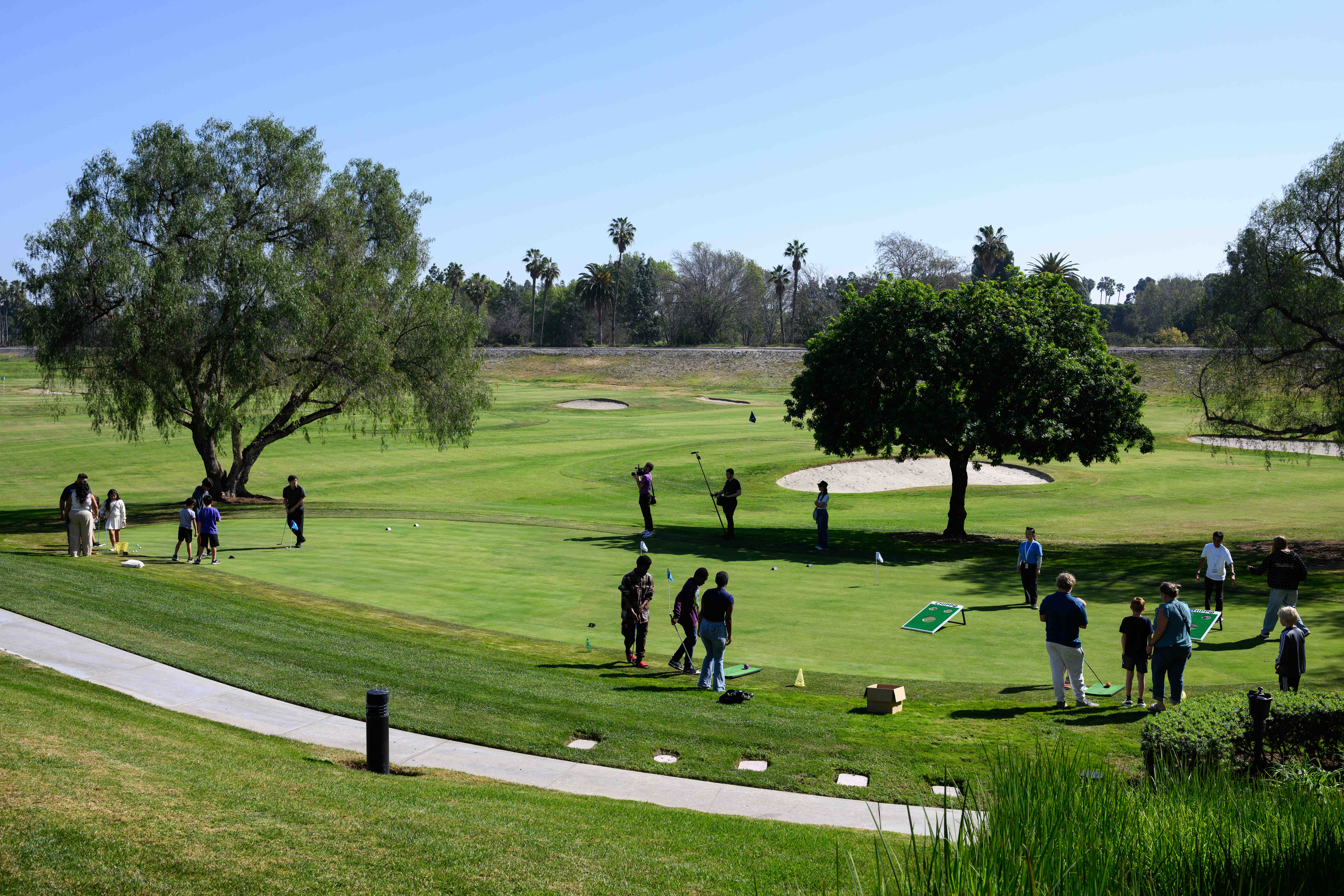 Families try out the putting area during an event celebrating...