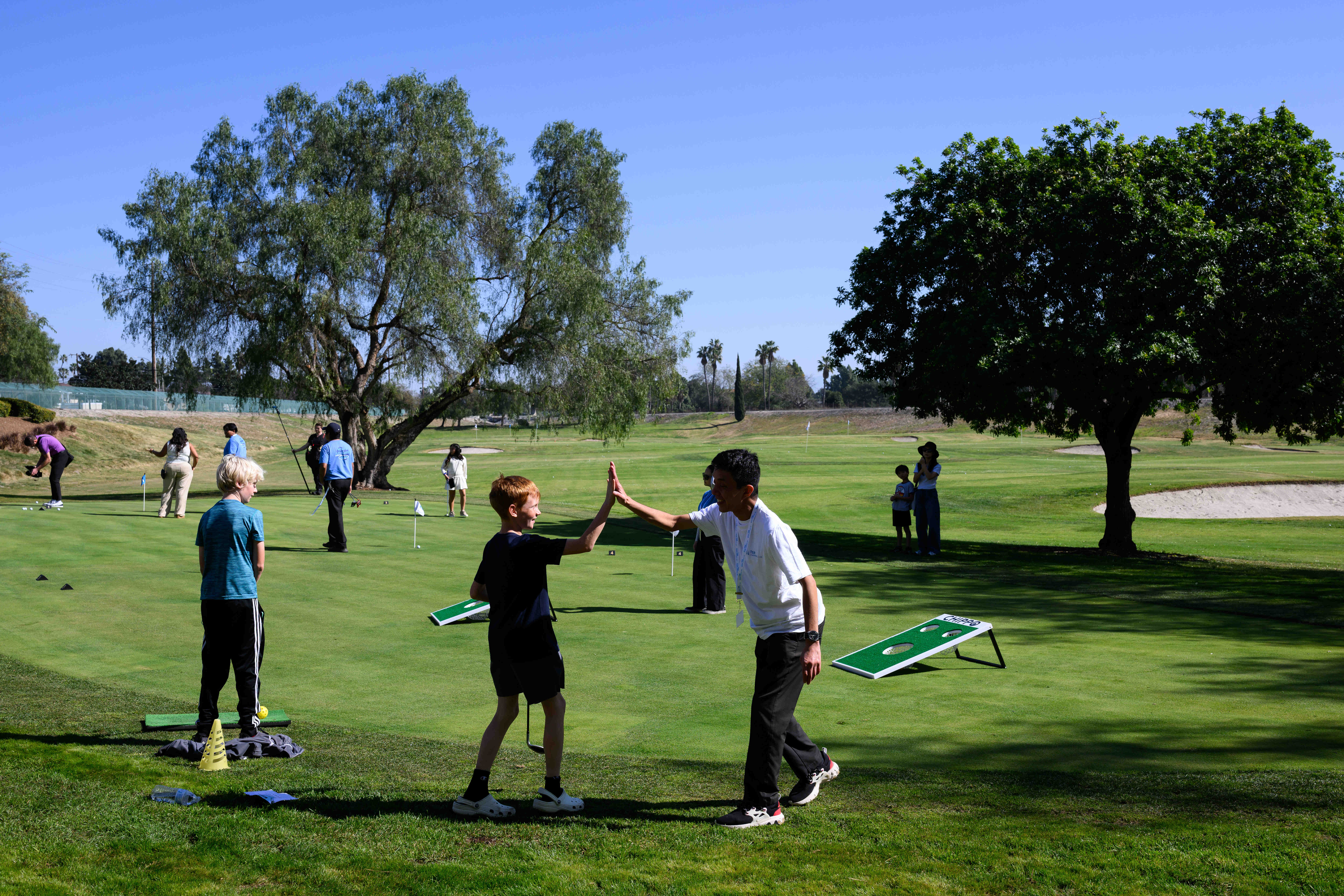 Families try out the putting area during an event celebrating...