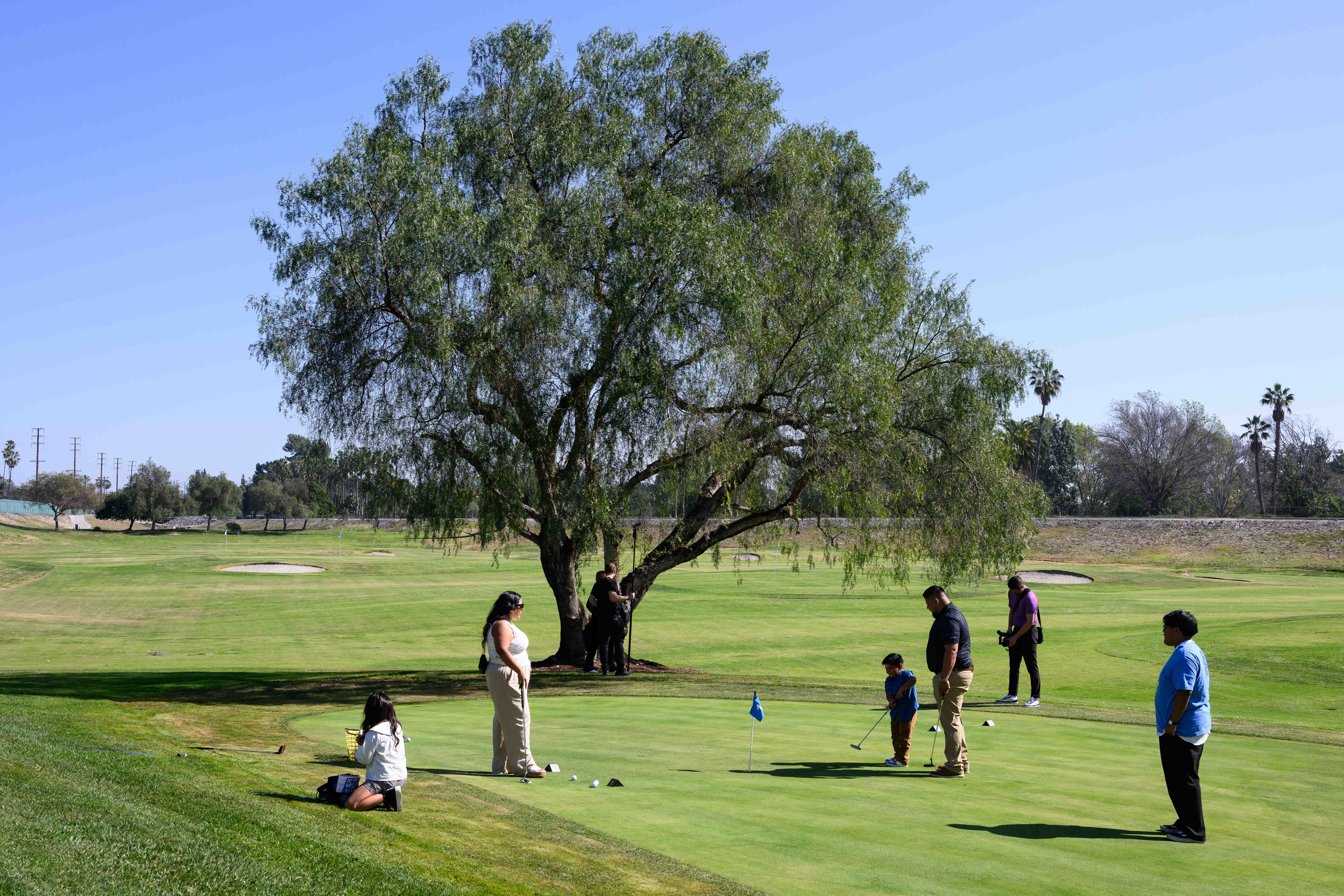 Families try out the putting area during an event celebrating...