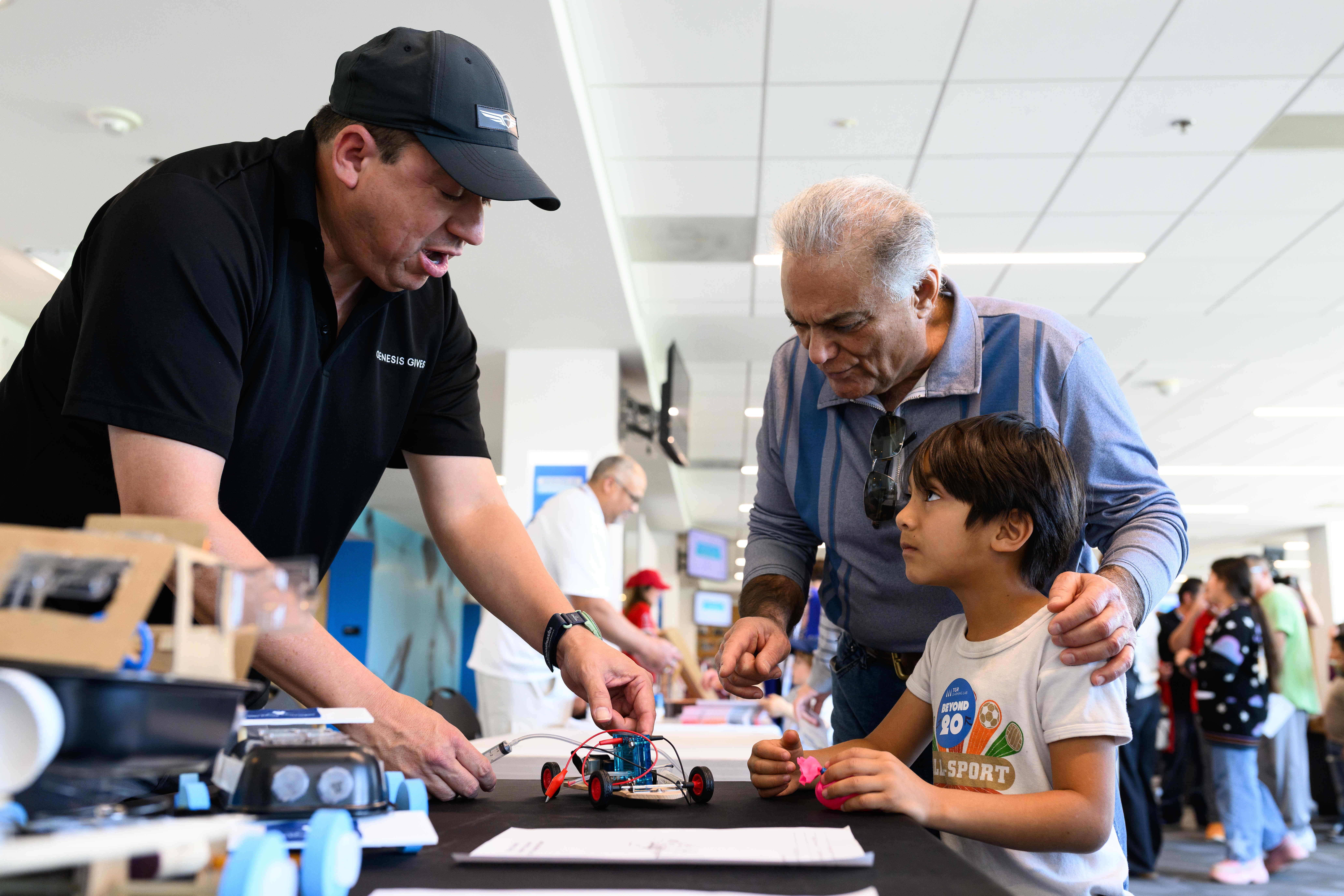 A spokesperson from Genesis speaks with a family during an...
