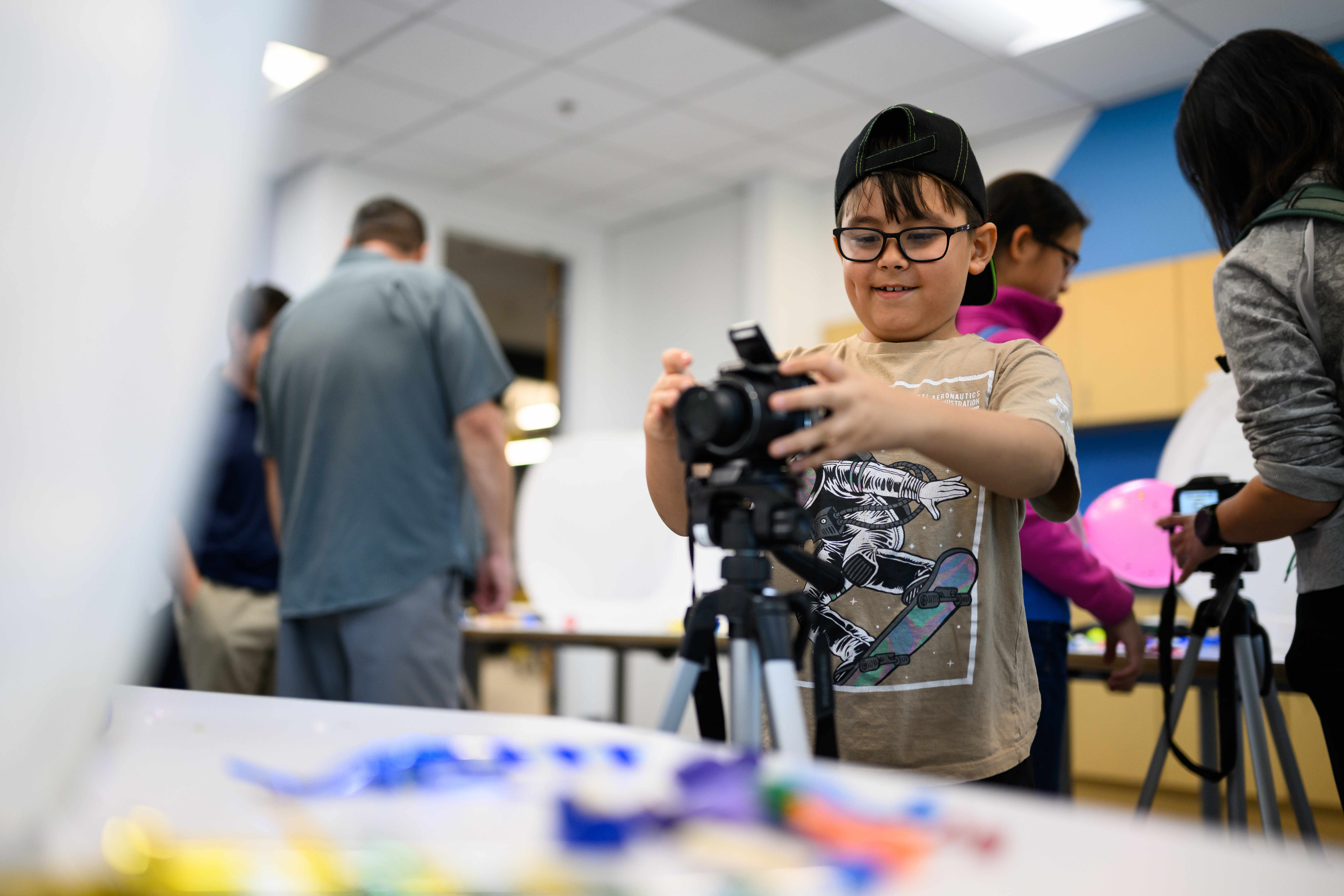 Asher East-Vu, 9, learns to use a camera during an...