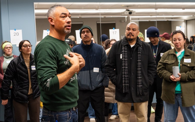 Councilmember Sean Elo-Rivera gestures towards his heart while speaking to assembled volunteers.