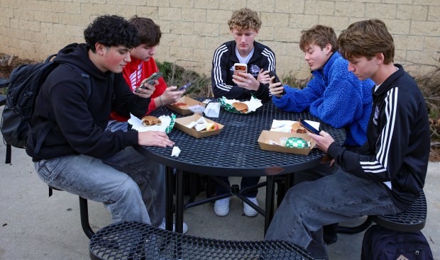 Ramona High School students are allowed to use their phones during lunch to check emails, text messages and social media accounts. Shown around the table from left are Adrian Ornelas, Ryder Bacling, Tate Swanson, Wolfgang Wood and Tyler Solt. (Stephanie Rene Ogilvie)