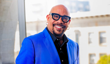 Black man in thick glasses and blue suit jacket