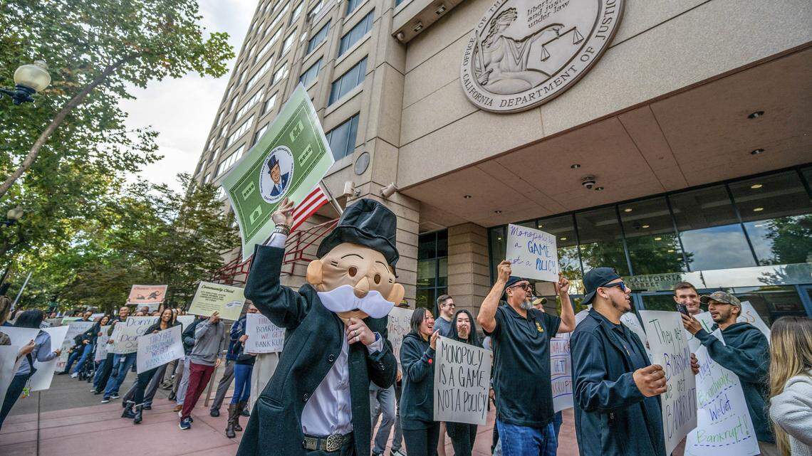 Jackson McFetridge, dressed as Mr. Monopoly, joins card room employees and union members protesting outside Attorney General Rob Bonta’s Sacramento office on Wednesday, Oct. 22, 2025, against proposed regulations that would effectively ban blackjack-style games and severely limit player-dealer games in California card rooms.