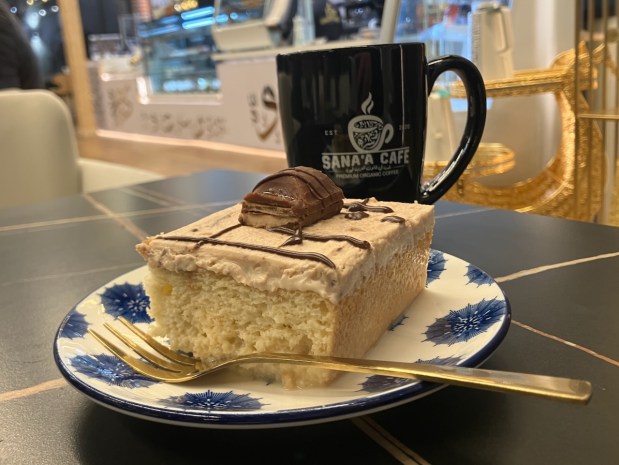 A slice of milk cake and a mug of mofawar, medium-roast coffee with cardamom and cream, are among the menu items at Sana'a Cafe in Redwood City. (Kate Bradshaw/Bay Area News Group)