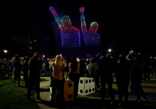 People watch a drone show which depicts San Jose State University alumni Tommie Smith and John Carlos in Discovery Meadow on Super Bowl Opening Night in downtown San Jose, Calif., on Monday, Feb. 2, 2026. They performed a Black power salute during the medal ceremony for the 200 meter final in Mexico City in 1968. (Nhat V. Meyer/Bay Area News Group)