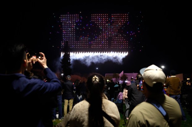 People watch a drone show which depicts the Super Bowl LX logo on Super Bowl Opening Night in Discovery Meadow in downtown San Jose, Calif., on Monday, Feb. 2, 2026. (Nhat V. Meyer/Bay Area News Group)
