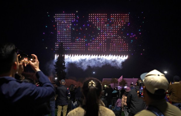 People watch a drone show which depicts the Super Bowl LX logo on Super Bowl Opening Night in Discovery Meadow in downtown San Jose, Calif., on Monday, Feb. 2, 2026. (Nhat V. Meyer/Bay Area News Group)