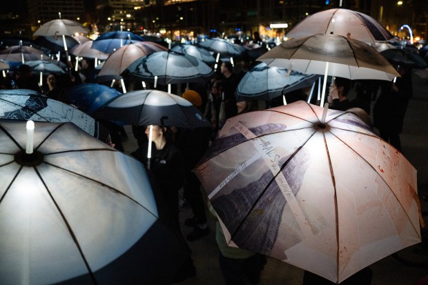 Participants march with umbrellas printed with aerial photographs at City Hall in San Jose, Calif., on Saturday, Jan. 31, 2026. (Thien-An Truong for Bay Area News Group)