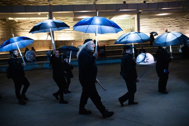 Participants march with umbrellas printed with aerial photographs at City Hall in San Jose, Calif., on Saturday, Jan. 31, 2026. (Thien-An Truong for Bay Area News Group)