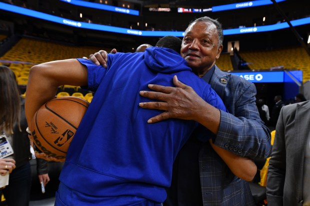 Golden State Warriors' Jordan Poole (3) greets the Rev. Jesse Jackson before the start of Game 5 of the NBA Finals at the Chase Center in San Francisco, Calif., on Monday, June 13, 2022. (Jose Carlos Fajardo/Bay Area News Group)