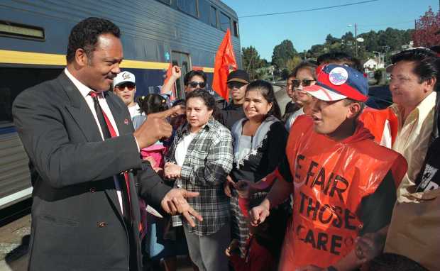 In January of 2008, Jesse Jackson walked off an Amtrak train in Martinez and greeted a group of workers from Hillhaven Corp. nursing homes and spoke about the issues they face before they all boarded the train which was going to a rally in Oakland. Here Jackson talks to Robert Bande, right in orange plastic, who works for Hillhaven nursing home in Concord. (Contra Costa Times/Dan Rosenstrauch)