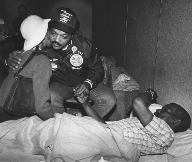 Jesse Jackson comforts Charles Alexander and his wife Jessie at the Red Cross facility in Moscone Center. They were displaced by the 1989 earthquake. (Gary Reyes/Oaklnd Tribune Archives)