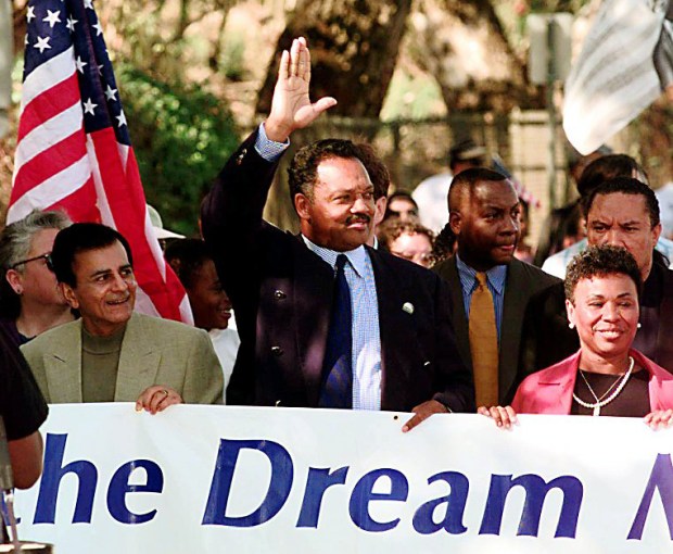 Jesse Jackson, center, waves while marching with radio personality Kasey Kasem, left, and State Sen. Barbara Lee, D-Oakland, toward the State Capitol in Sacramento, Calif., Monday Oct. 27, 1997. Jackson led a group of hundreds in a march to protest against California's anti-affirmative action policies. (AP Photo/Eric Risberg)