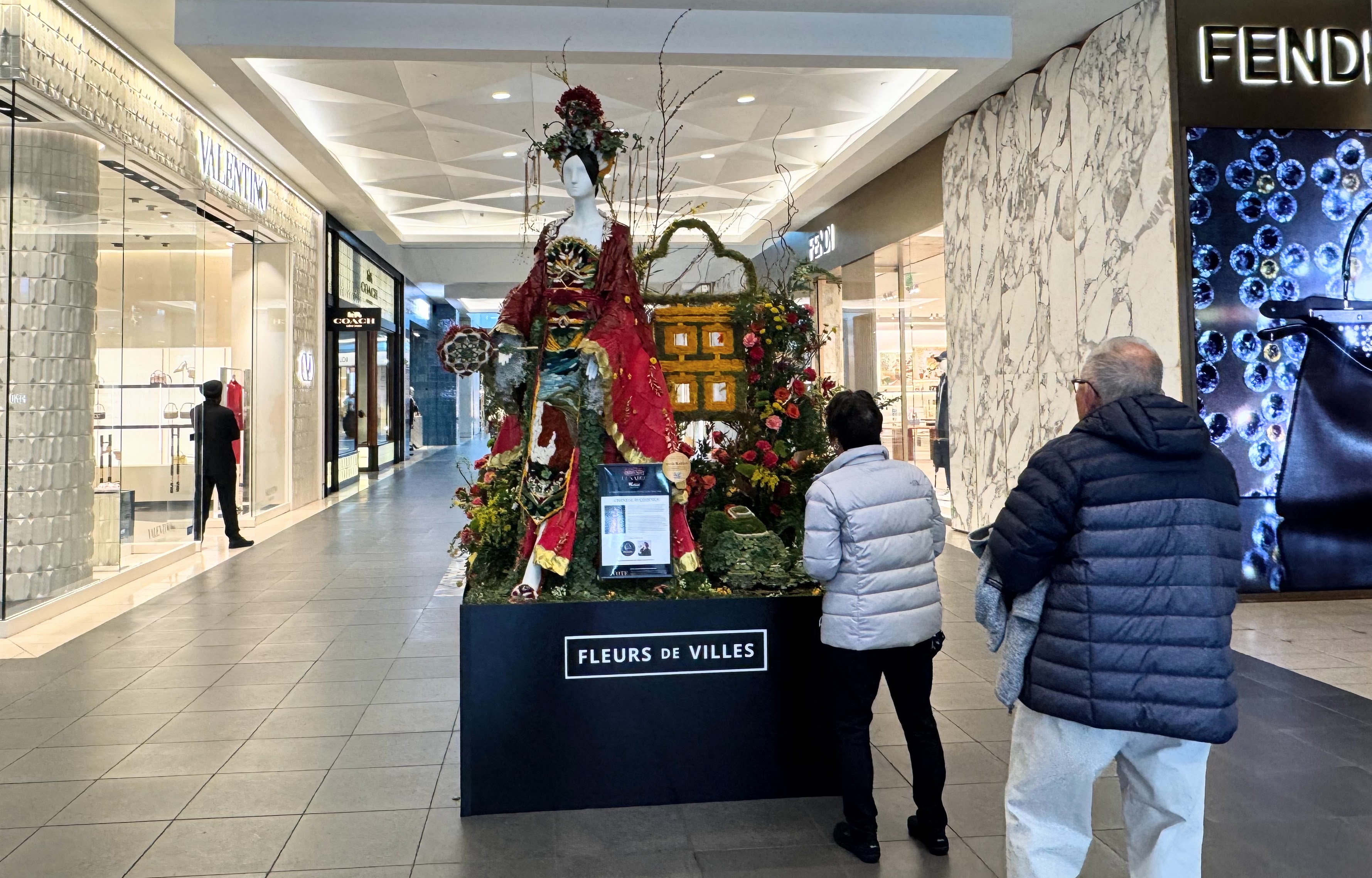 Shoppers at Westfield Valley Fair look at a floral and...