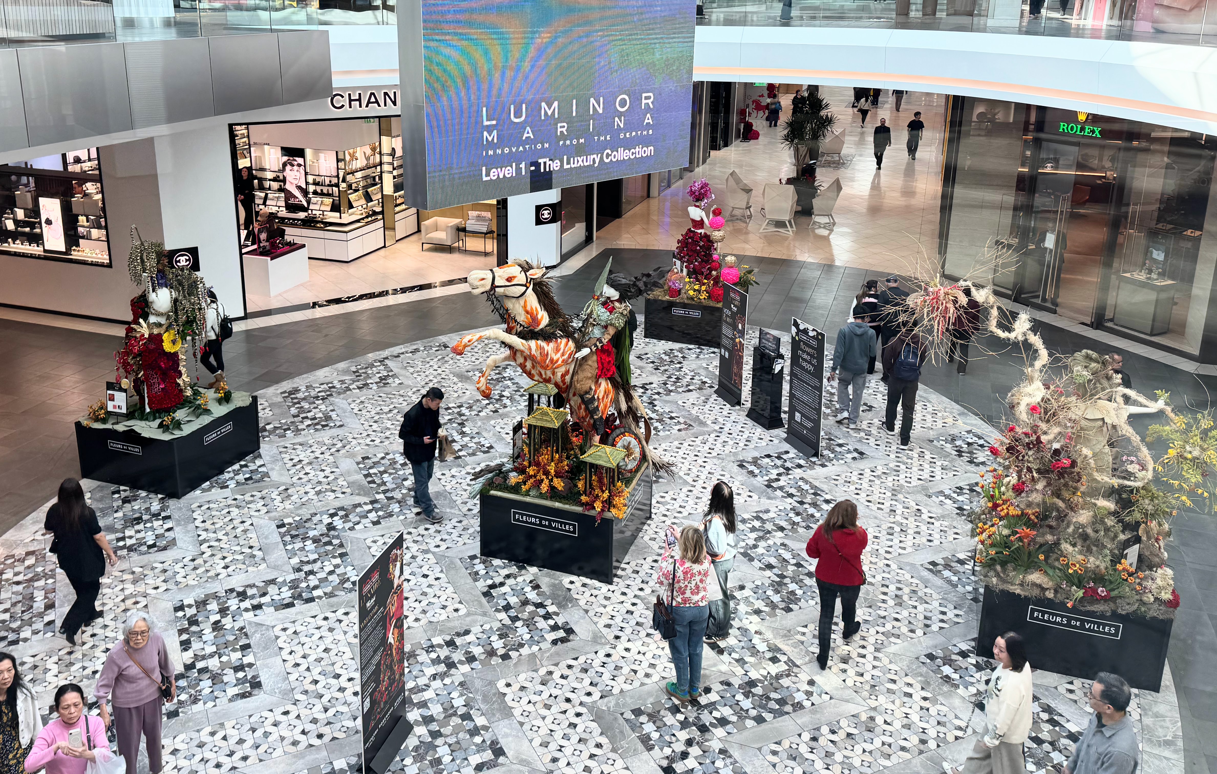 Shoppers at Westfield Valley Fair look at floral and plant...