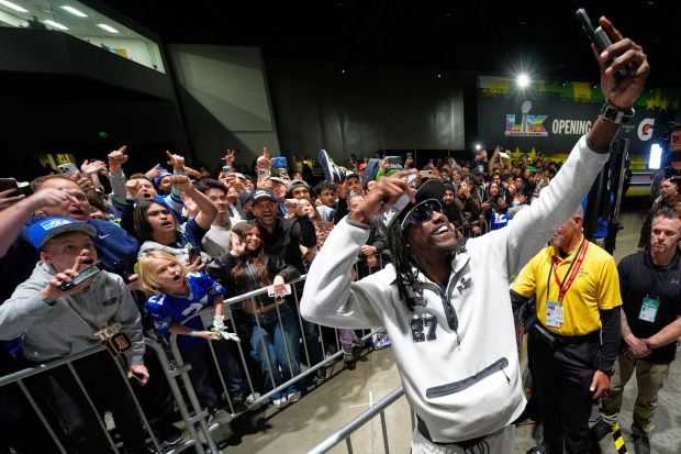 Seattle Seahawks cornerback Riq Woolen takes a picture during the NFL Super Bowl Opening Night, Monday, Feb. 2, 2026, in San Jose, Calif., ahead of the Super Bowl 60 football game between the Seattle Seahawks and the New England Patriots. (AP Photo/Charlie Riedel)