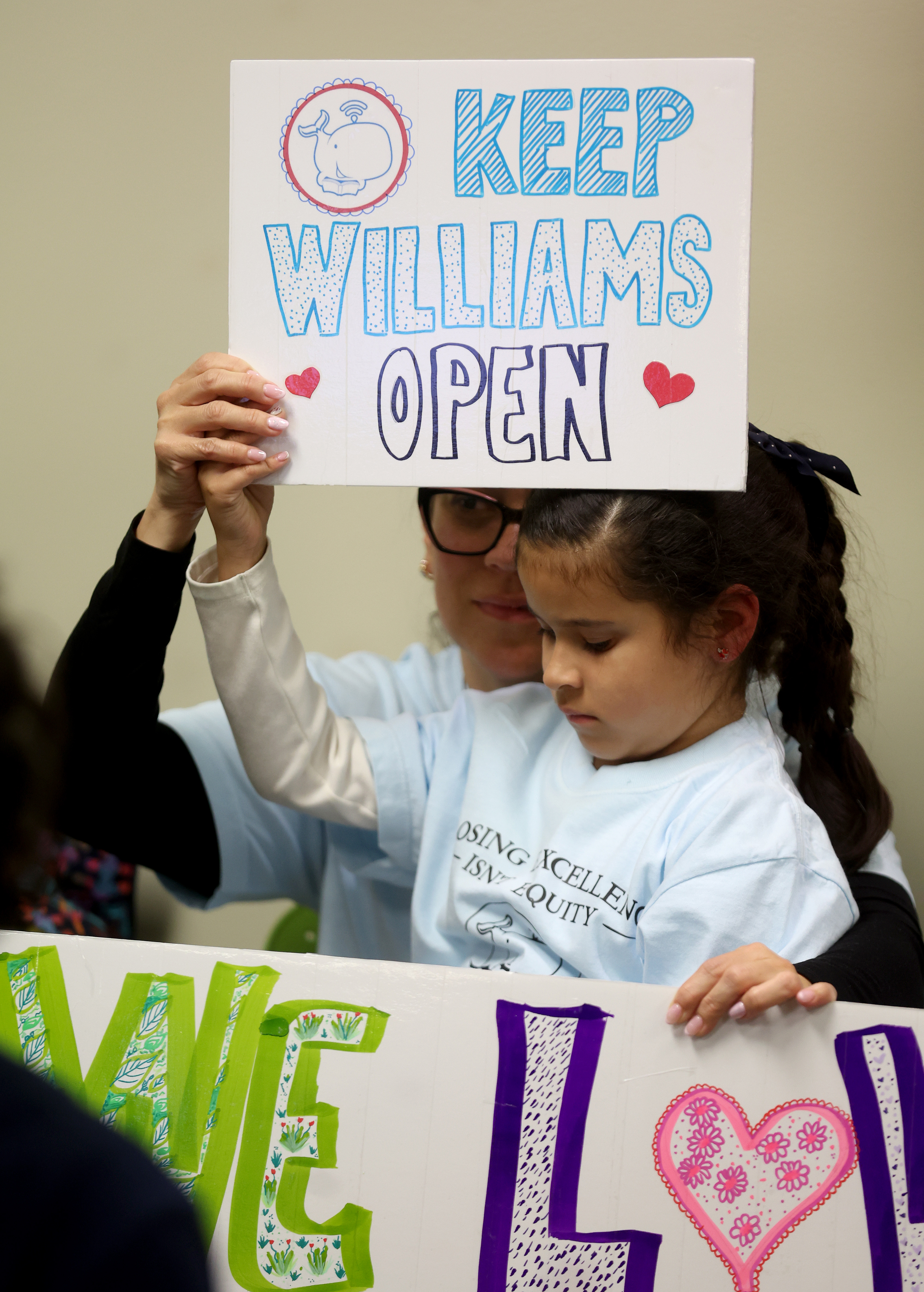 Angela Perez and her daughter Violet, 7, attend a meeting...
