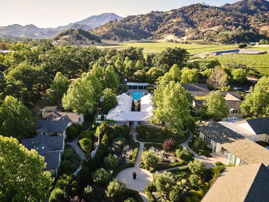 image shows aerial view of hotel tucked into green hills in the napa valley