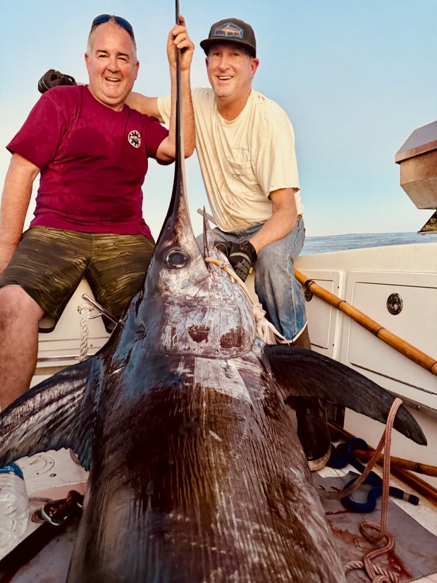 Santa Cruz angler Mike Baxter, right, inducted into the California Outdoors Hall of Fame on Jan. 17, and cohort Jason Young are all smiles after landing a 322-pound swordfish off the coast of San Diego in early December. (Contributed)