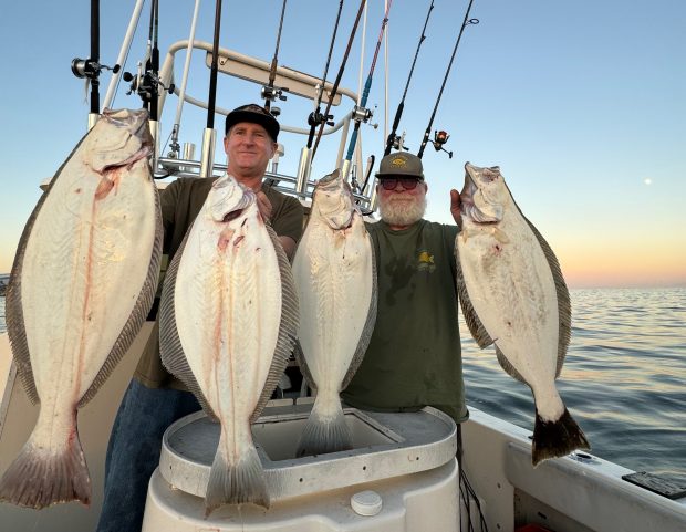 Santa Cruz anglers Mike Baxter, left, and Allen Bushnell hoist limits of Capitola halibut. (Contributed)