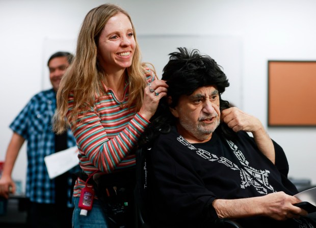 San Diego, CA - February 11: Hair and makeup artist Sarah Ankerman adjusts a wig for actor Ken Davitian before shooting a scene for the film Concert Heroes at Spark Studio Soundstage in Kearny Mesa on February 11, 2026 in San Diego, CA. (K.C. Alfred / The San Diego Union-Tribune)