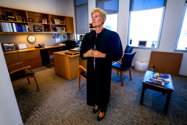 SAN DIEGO, CA - December 29, 2025: San Diego Superior Court Judge Joan Weber, who is retiring, puts on her robe while in her chambers at the San Diego Central Courthouse in downtown San Diego on Monday, December 29, 2025. (Hayne Palmour IV / For The San Diego Union-Tribune)