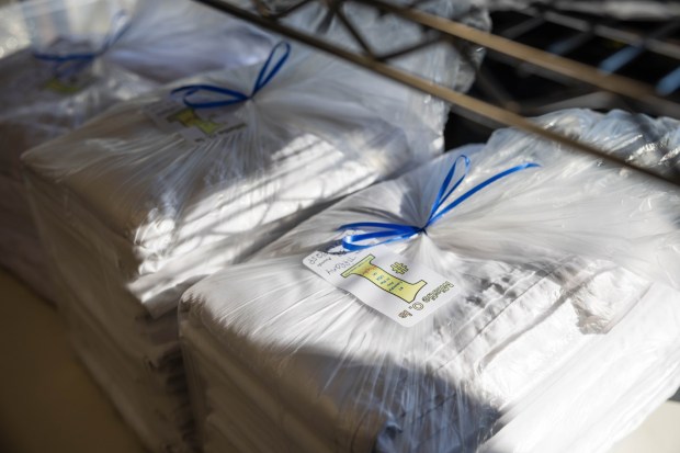 Mistie Osterhage uses stickers noting her number one rating in the Poplin app on bags of clean laundry, San Diego, Tuesday, Jan. 20, 2026. (Zoë Meyers / For The San Diego Union-Tribune)