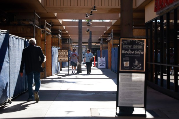 Shoppers walk past construction inside the Grossmont Center in La Mesa in mid-January. (Meg McLaughlin / The San Diego Union-Tribune)