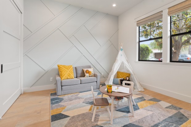 Designer Jen Pinto included a loveseat for story time, a tepee for cozy hideouts and a table for creating art in this playroom. (Jackson Design and Remodeling)