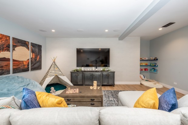 A play area is incorporated into a family room, with a tepee and a reading nook tucked in the corner. (Jackson Design and Remodeling)