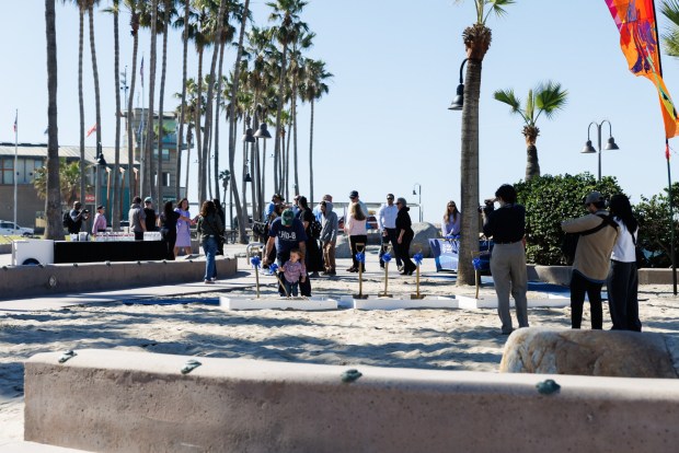 People gather at the future site of the "splash pad" in Imperial Beach on Wednesday, Feb. 25, 2026. The splash pad will include arched water jets, updated sidewalks and accessible showers. Construction is expected to complete by the end of the year. (Kristian Carreon / The San Diego Union-Tribune)